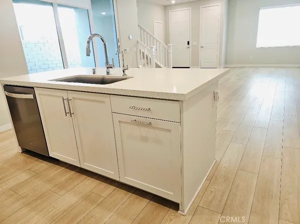a kitchen with a sink cabinets and wooden floor