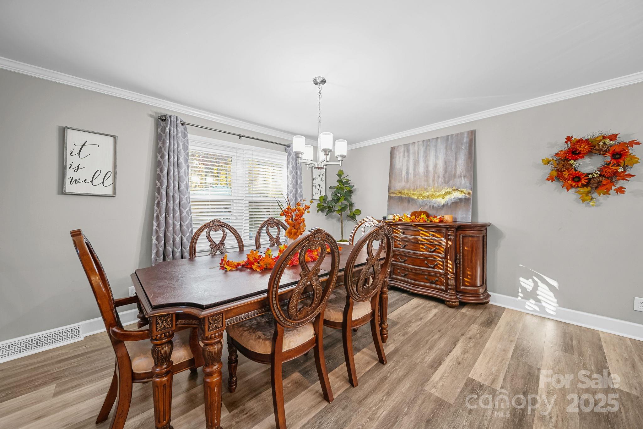 4724 Weddington Matthews Road Matthews, NC 28104 - Photo 8 of 42 a dining room with furniture a chandelier and wooden floor