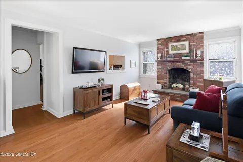 a living room with furniture a flat screen tv and a fireplace
