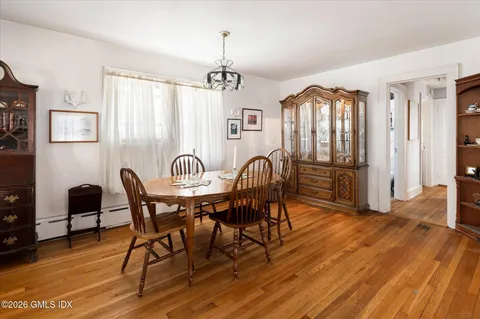 a view of a a dining room with furniture window and wooden floor