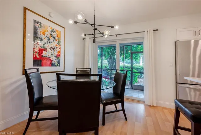 a dining room with furniture a chandelier and wooden floor