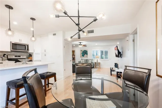 a living room with furniture a flat screen tv and kitchen view