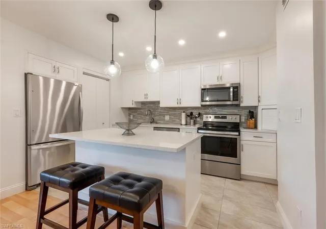 a kitchen with stainless steel appliances a stove a sink island and a refrigerator