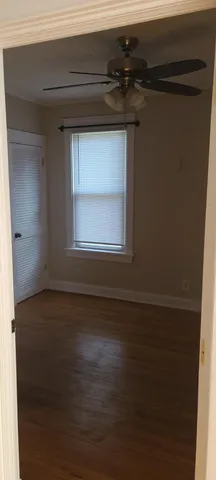 a view of a small space with wooden floor and a window