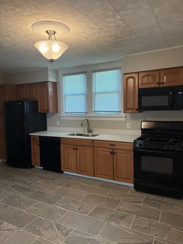 a kitchen with stainless steel appliances granite countertop a stove a sink and a microwave