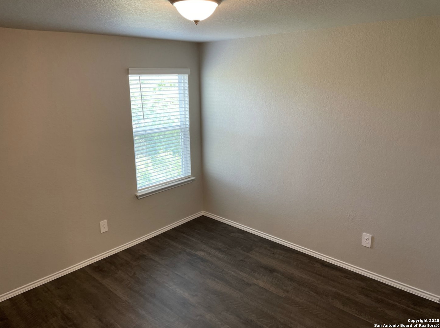 13128 Candace Way St. Hedwig, TX 78152 - Photo 7 of 14 an empty room with wooden floor and windows