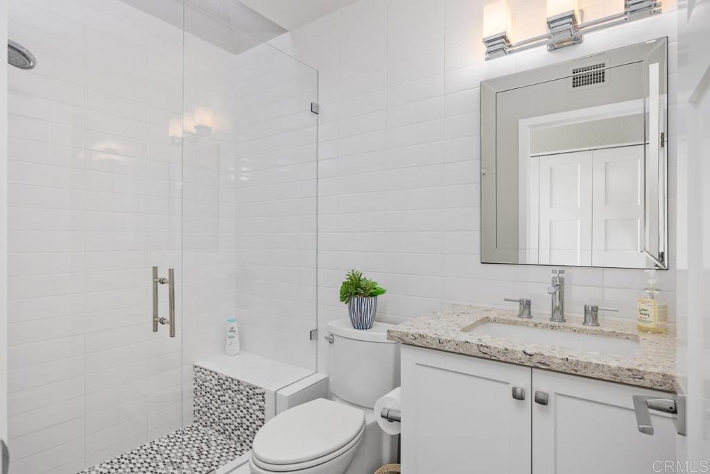 6939 Carnation Drive Carlsbad, CA 92011 - Photo 11 of 13 a bathroom with a granite countertop toilet sink and mirror