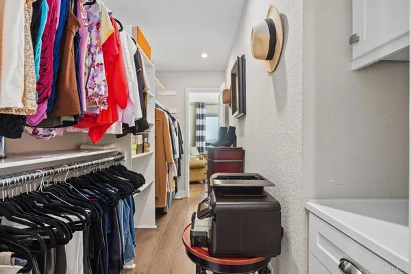 a view of walk in closet with clothes and shoes