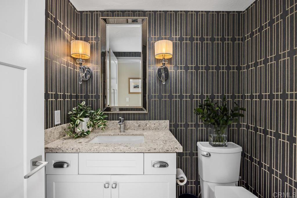 6939 Carnation Drive Carlsbad, CA 92011 - Photo 7 of 13 a bathroom with a granite countertop sink and a mirror