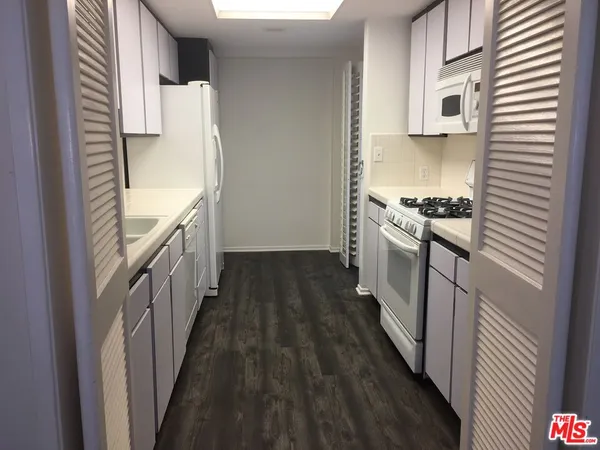 a kitchen with granite countertop a stove and a refrigerator