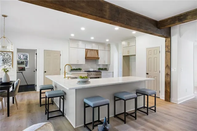 a kitchen with a dining table chairs and wooden floor