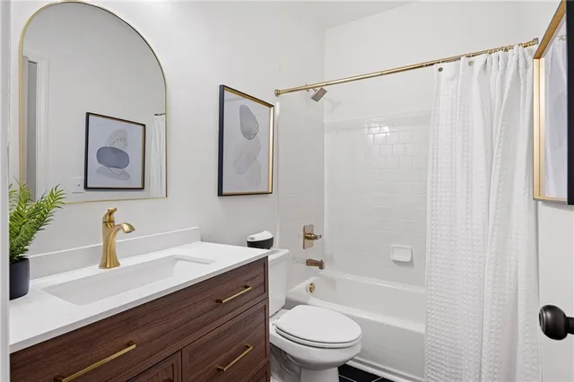 a bathroom with a sink a toilet a mirror and shower