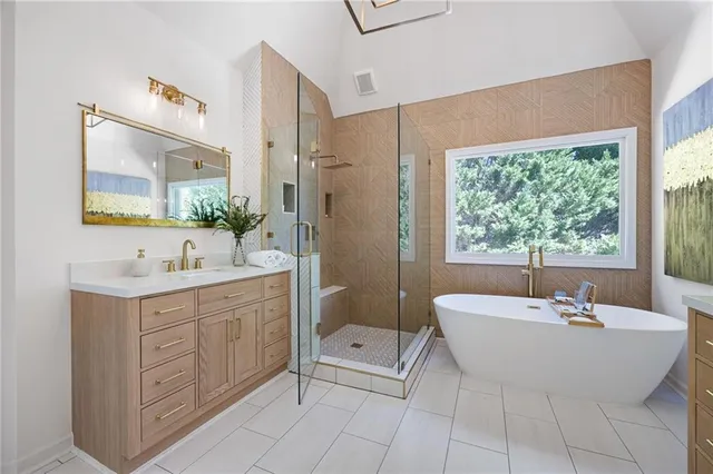 a bathroom with a granite countertop sink a mirror a glass door a shower and vanity