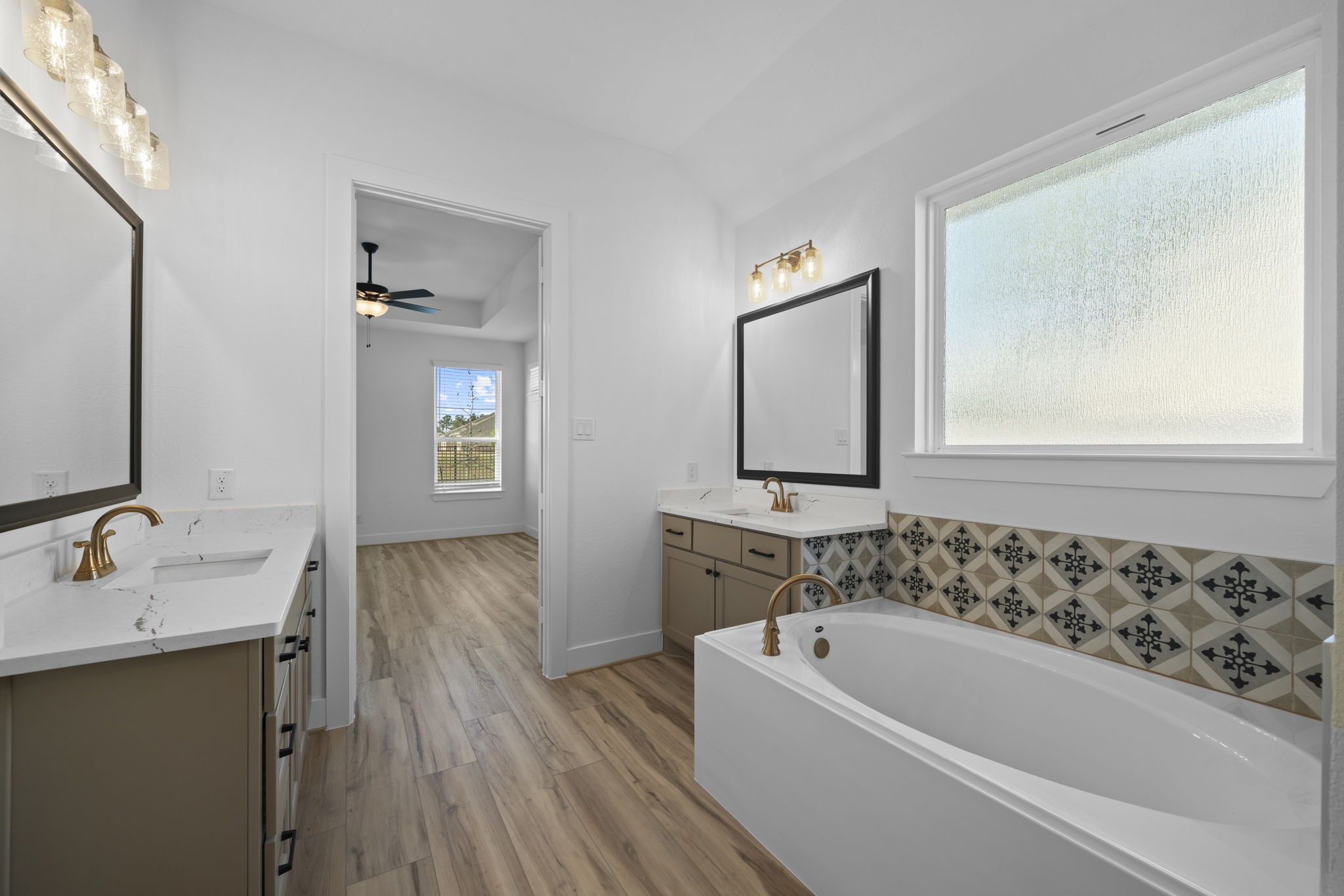 15508 Leopard Lily Lane Conroe, TX 77302 - Photo 14 of 39 a bathroom with a bathtub a sink and a mirror