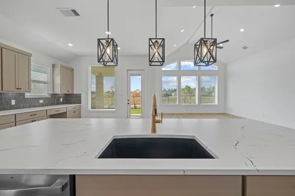 a kitchen with stainless steel appliances granite countertop a sink a stove and a wooden floors