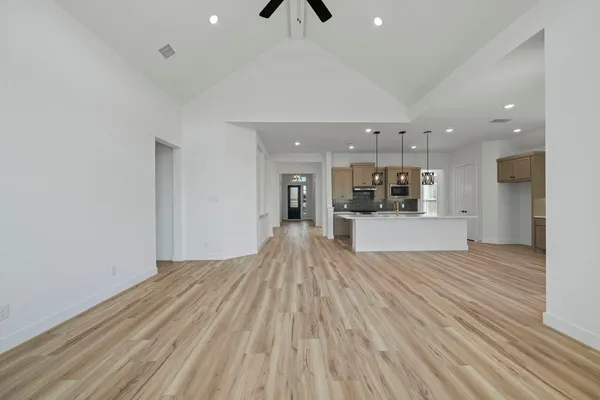 a view of a room with window ceiling fan and kitchen space