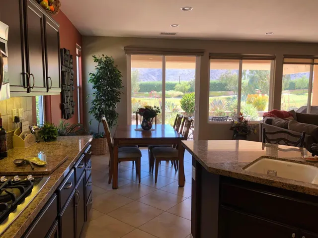 a kitchen with stainless steel appliances granite countertop sink stove and table