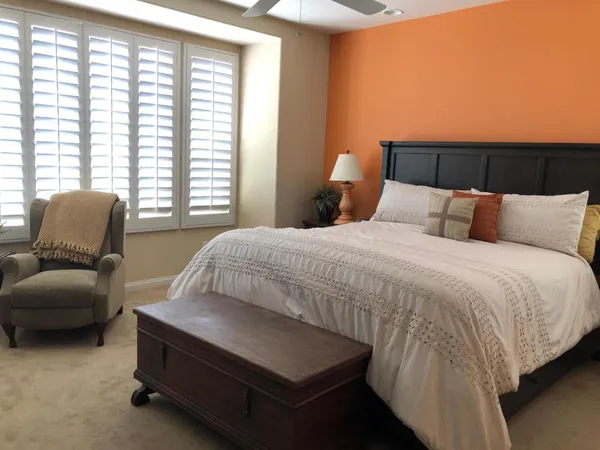 a bedroom with a bed and a couch with window