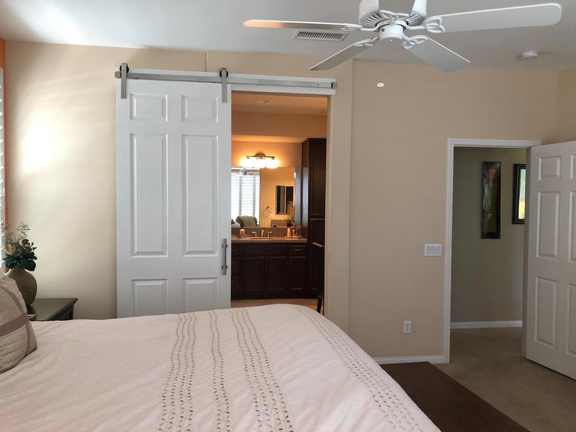 81565 Rustic Canyon Drive La Quinta, CA 92253 - Photo 8 of 12 a bedroom with a bed and a chandelier