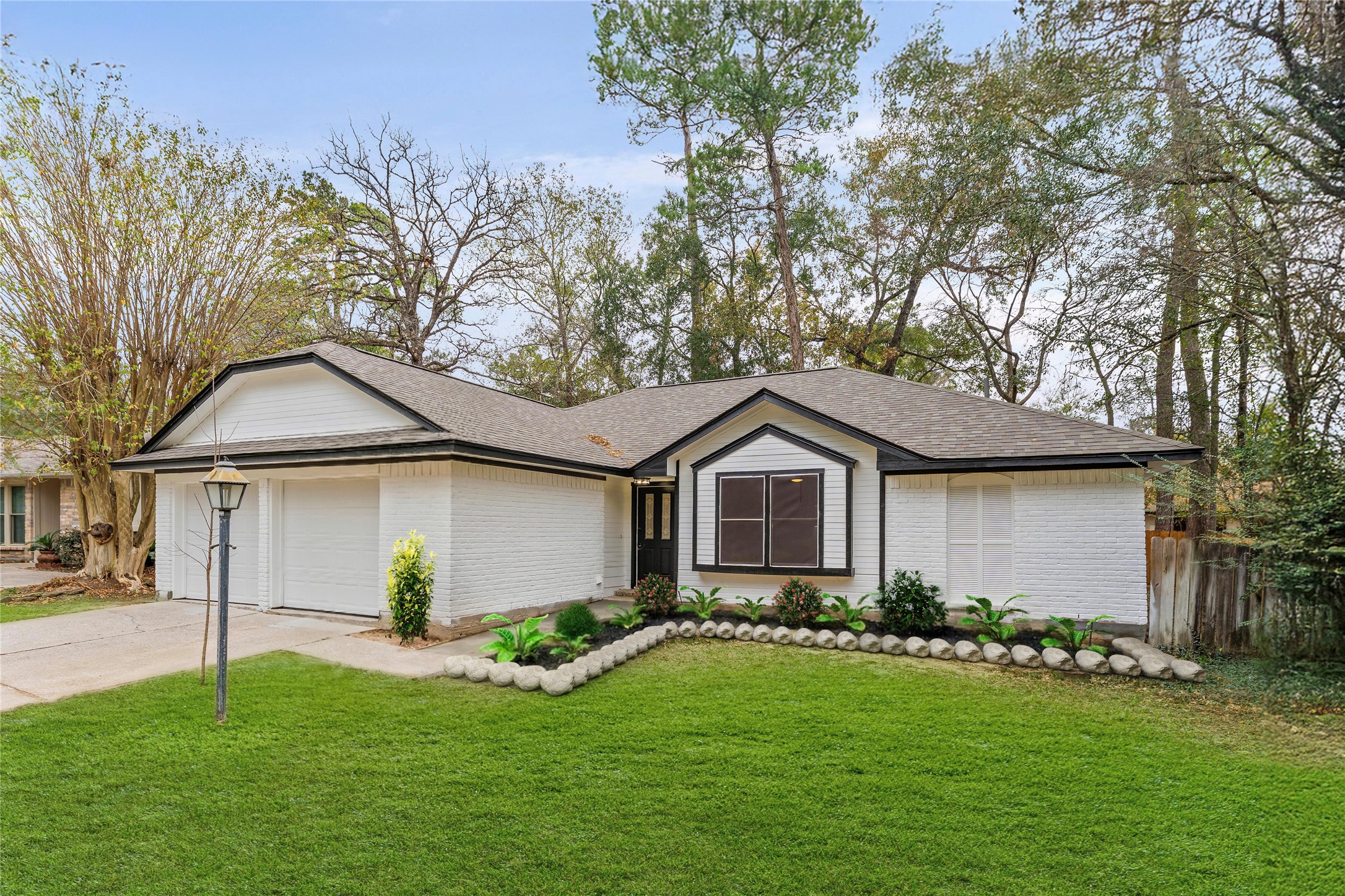 30 North Drifting Leaf Court Spring, TX 77380 - Photo 2 of 42 Garage doors are now painted black. Virtually staged landscaping