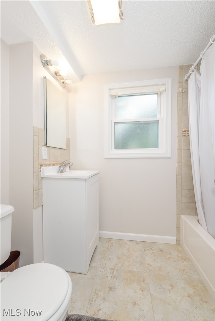 4051 Stow Road Stow, OH 44224 - Photo 19 of 38 Updated full bathroom with tile patterned flooring, toilet, a textured ceiling, and vanity