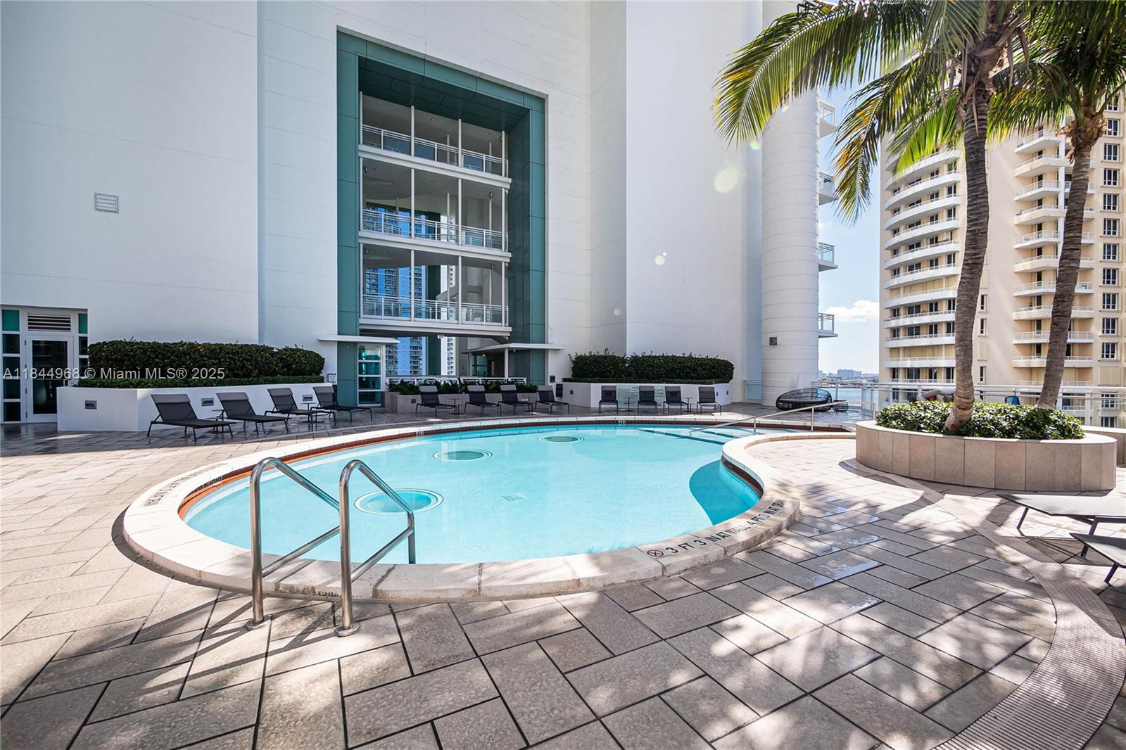 900 Brickell Key Boulevard, Unit 2005 Miami, FL 33131 - Photo 16 of 19 a swimming pool with outdoor seating