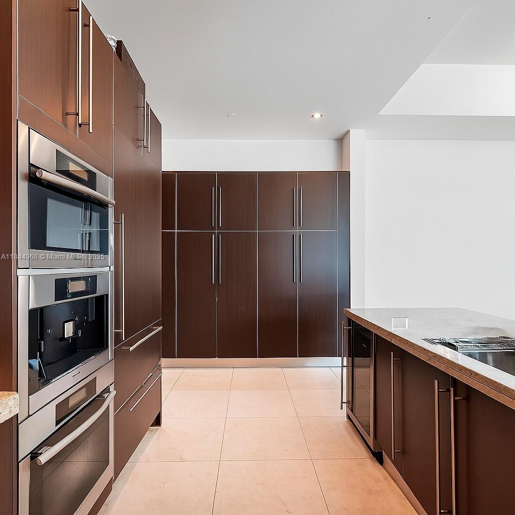900 Brickell Key Boulevard, Unit 2005 Miami, FL 33131 - Photo 5 of 19 a kitchen with stainless steel appliances a refrigerator and a stove top oven