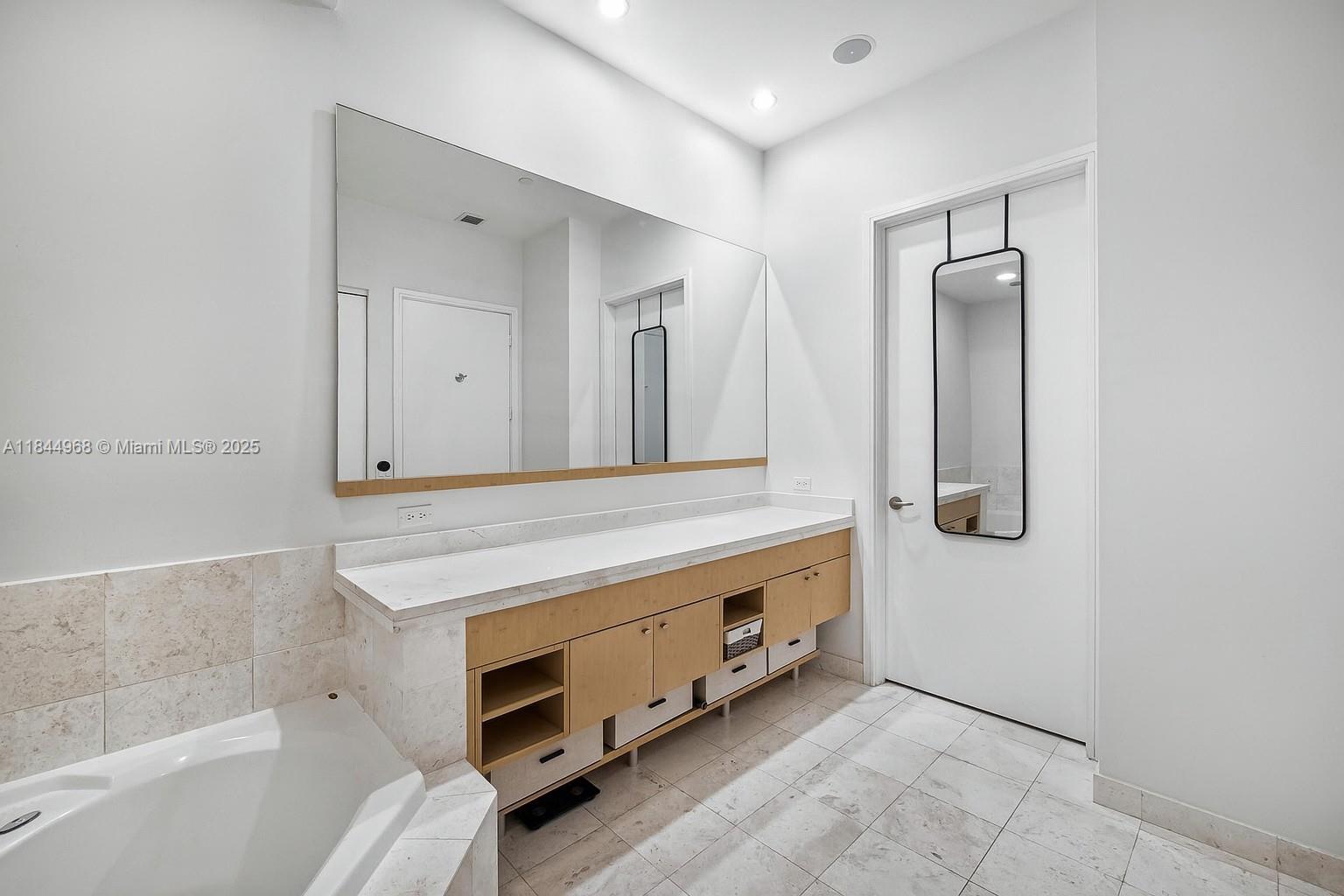 900 Brickell Key Boulevard, Unit 2005 Miami, FL 33131 - Photo 9 of 19 a bathroom with a tub sink and mirror