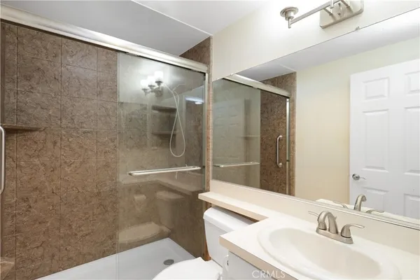 a bathroom with a sink a toilet and shower