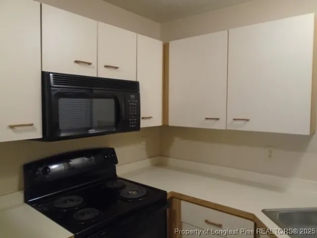 a view of a hallway with wooden floor windows and a bathroom