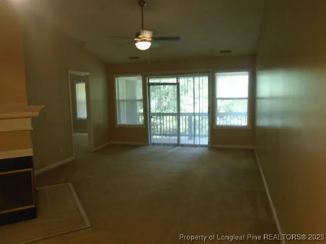 an empty room with a fireplace and fan