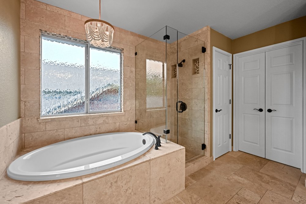 2823 Lantana Ridge Drive Austin, TX 78732 - Photo 21 of 34 a bathroom with a tub a window and a shower