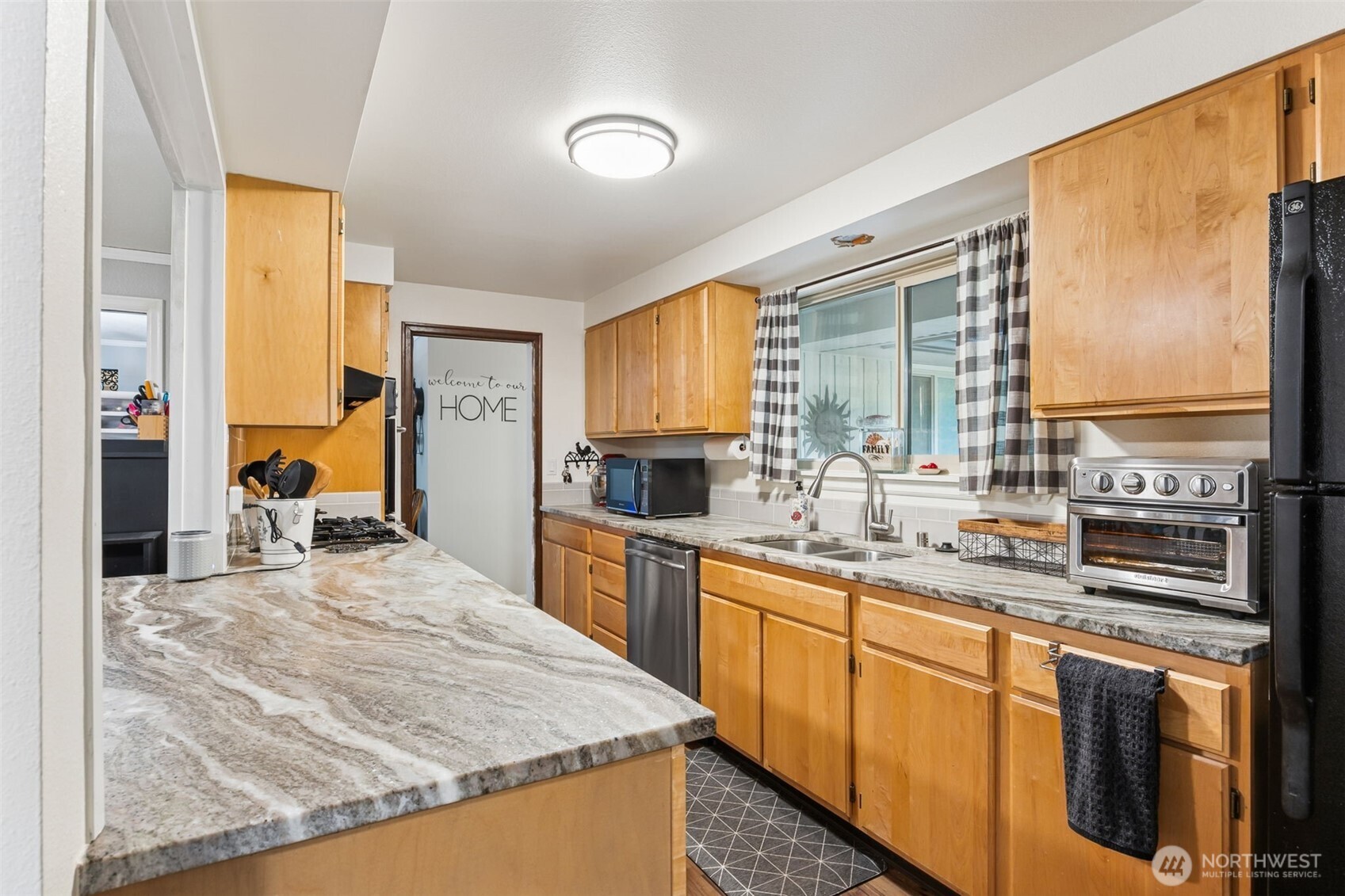 5700 Cooper Point Road Northwest Olympia, WA 98502 - Photo 13 of 31 a kitchen with stainless steel appliances granite countertop sink stove and refrigerator