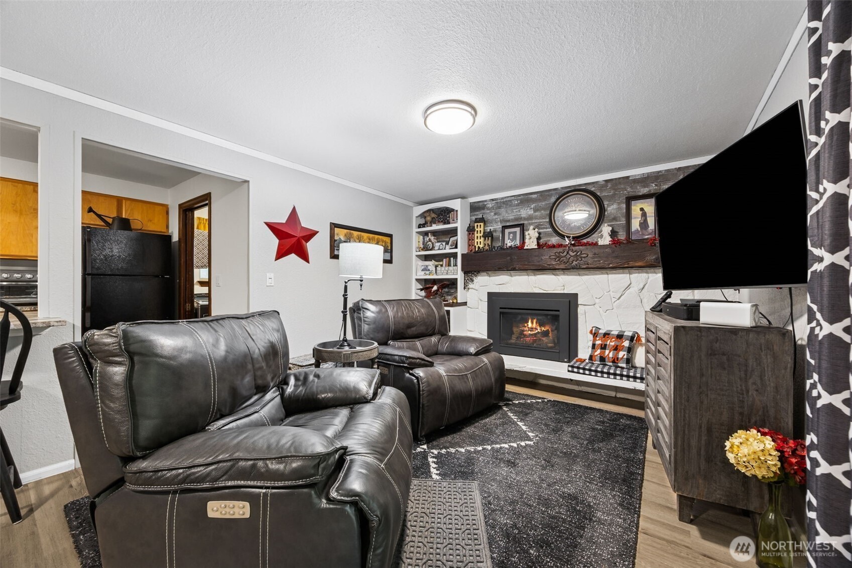 5700 Cooper Point Road Northwest Olympia, WA 98502 - Photo 16 of 31 a living room with furniture a flat screen tv and a fireplace