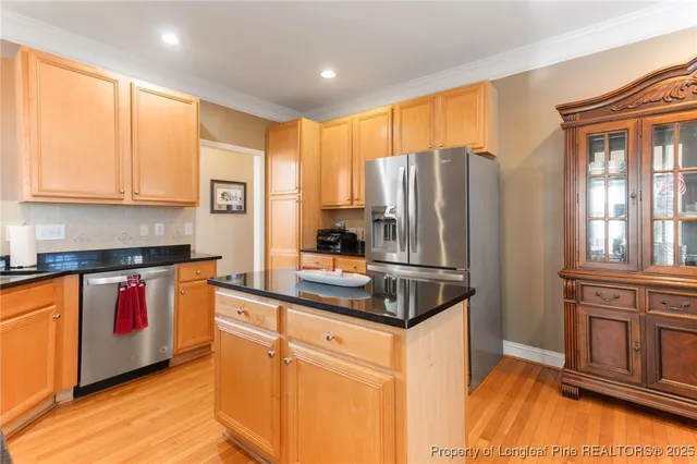 a kitchen with stainless steel appliances granite countertop a refrigerator and a stove top oven