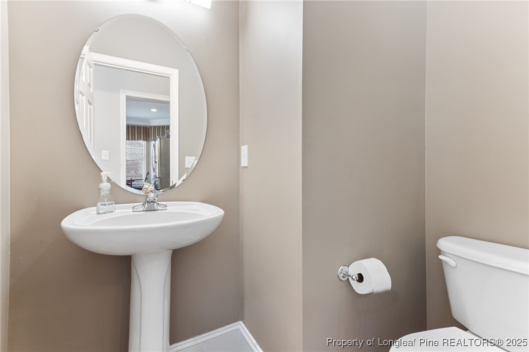 58 Cottswold Lane Spring Lake, NC 28390 - Photo 14 of 47 a bathroom with a toilet a sink and mirror