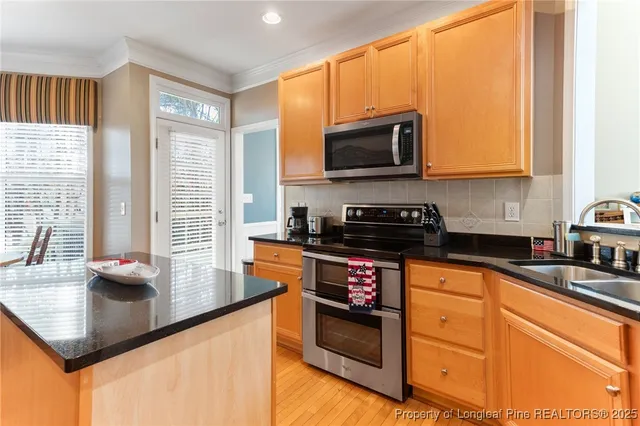 a kitchen with stainless steel appliances granite countertop a sink a stove and a microwave