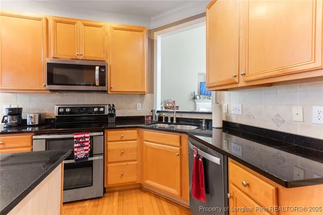 a kitchen with stainless steel appliances granite countertop a stove a sink and a microwave