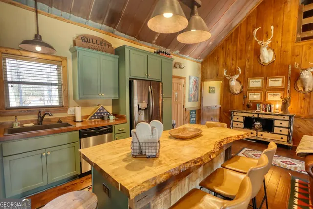 a kitchen with stainless steel appliances granite countertop a sink dishwasher stove and microwave with wooden floor