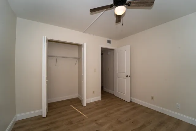 an empty room with closet and windows