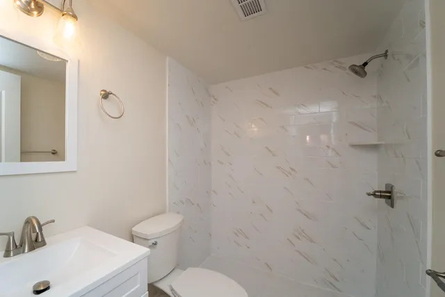 a bathroom with a sink a toilet and shower