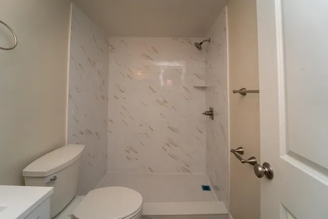 a white toilet sitting next to a bath tub