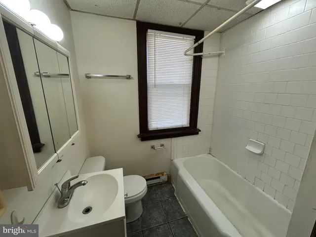 a bathroom with a tub sink and mirror
