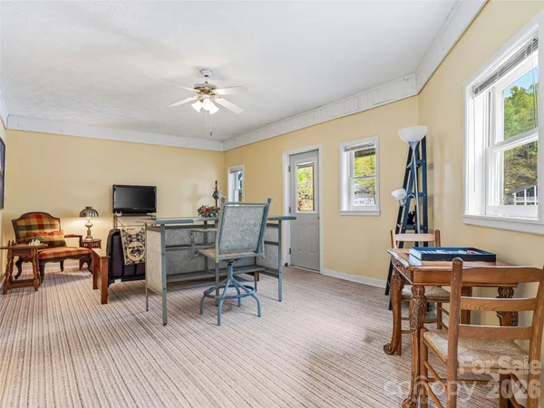 a workspace with wooden floor a chandelier fan a wooden table and chairs