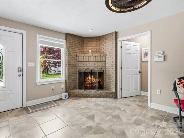 a view of an empty room with window and fire place