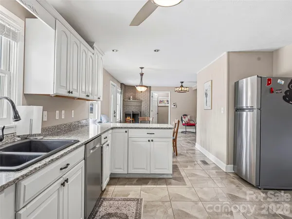 a kitchen with white cabinets and refrigerator