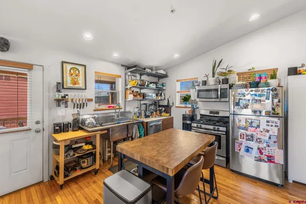 a room with stainless steel appliances furniture and a kitchen view