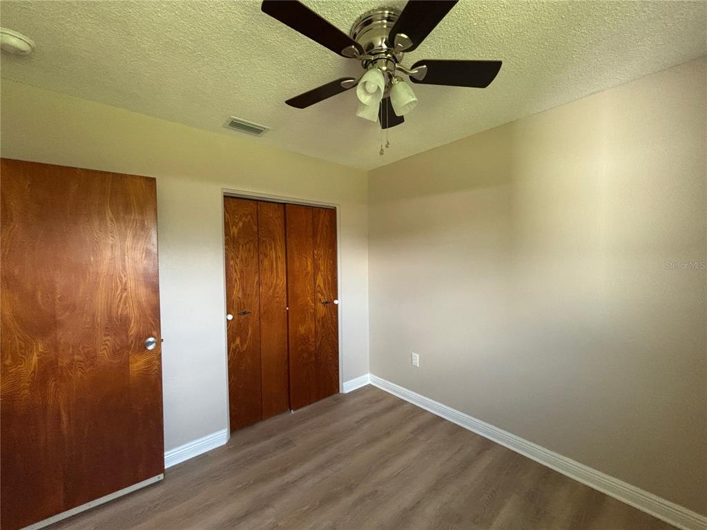 9950 52nd Terrace North St. Petersburg, FL 33708 - Photo 13 of 23 an empty room with a ceiling fan and wooden floor