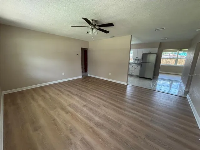 a view of a livingroom with wooden floor and a ceiling fan
