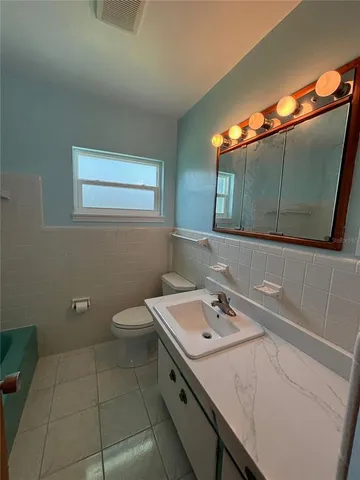 a bathroom with a sink a toilet and mirror